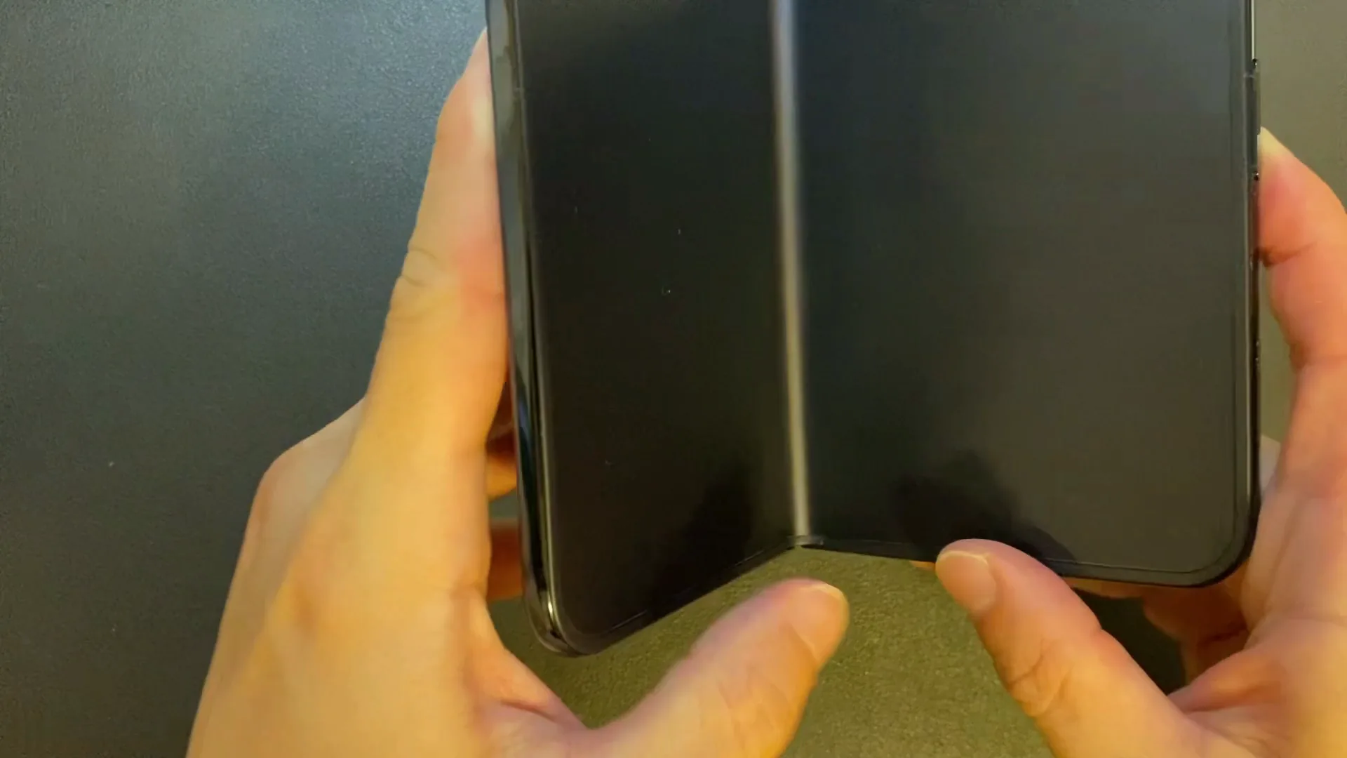 下のベゼルを持ってiPhone Duoを閉じるところ
